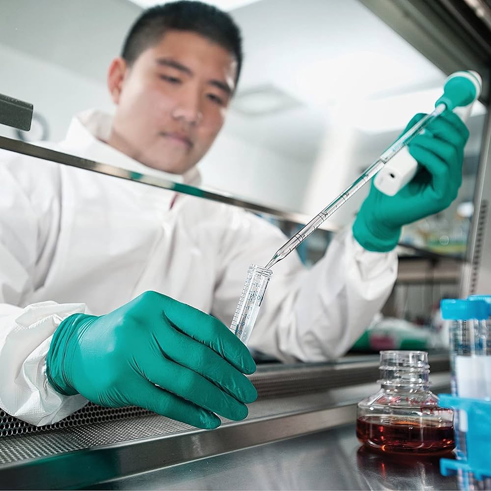 Lab worker wearing green nitrile gloves while conducting experiments or handling samples