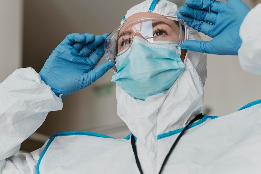 Healthcare worker wearing blue nitrile gloves while assisting a patient or performing medical tasks