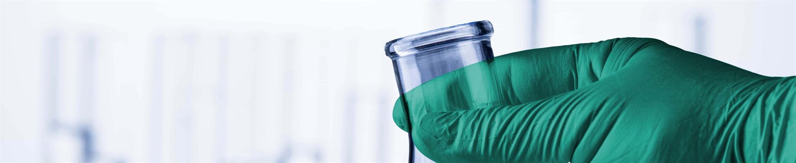 Gloved hand holding a laboratory flask wearing ChemTough green nitrile gloves